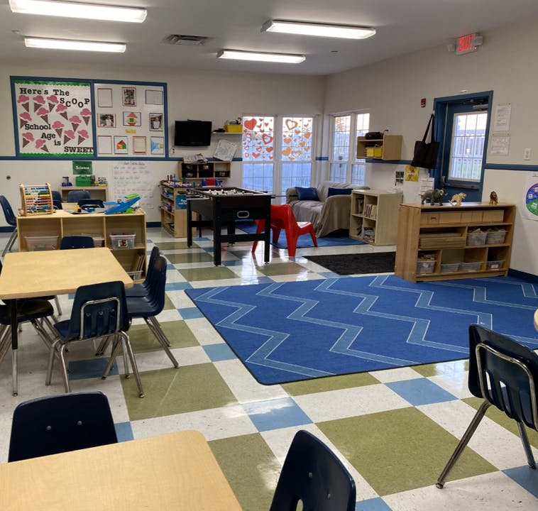 Classroom with tables, chairs, foosball table, and play area