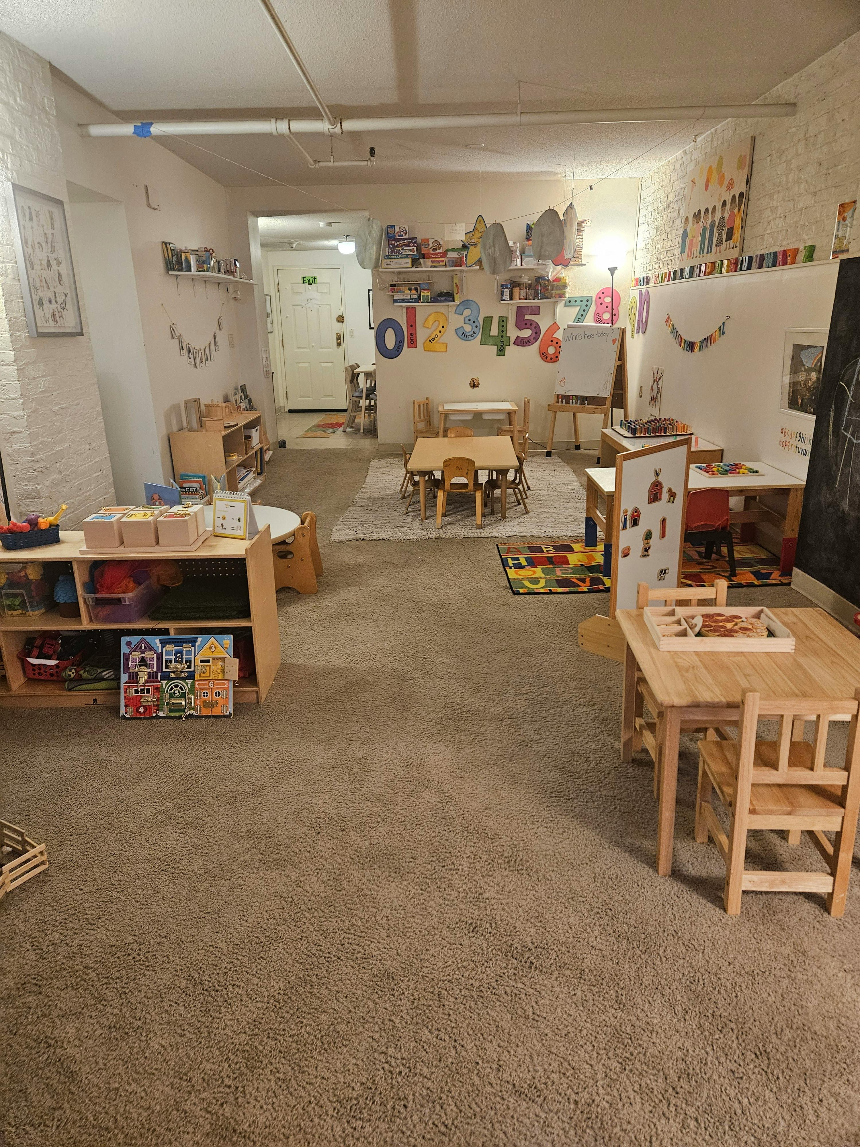 Classroom filled with small wooden furniture and educational toys