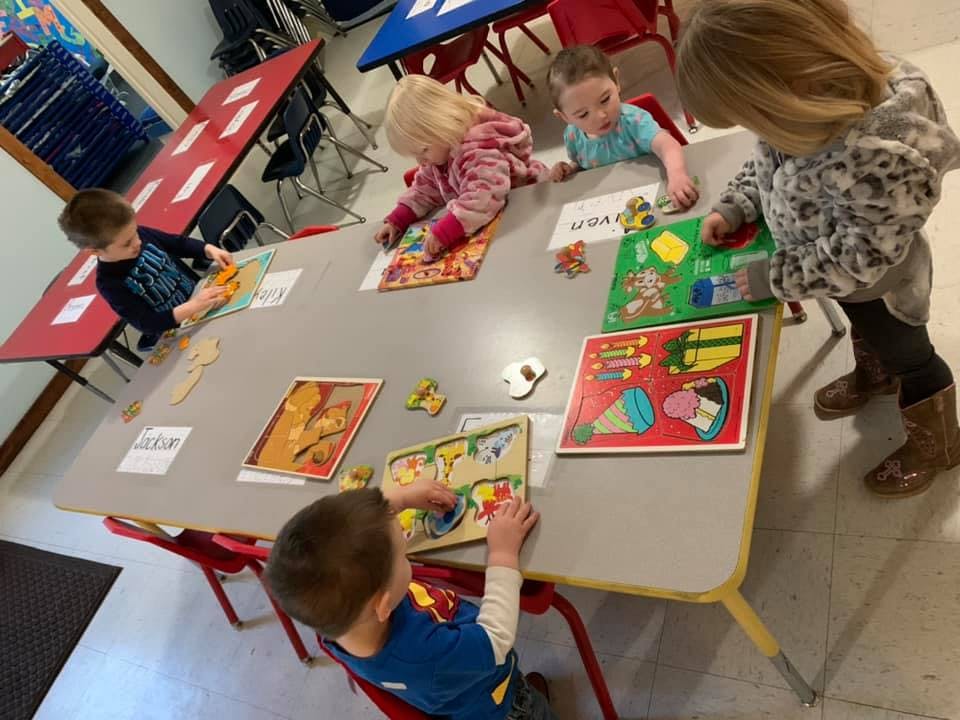 Children playing with puzzles at a table