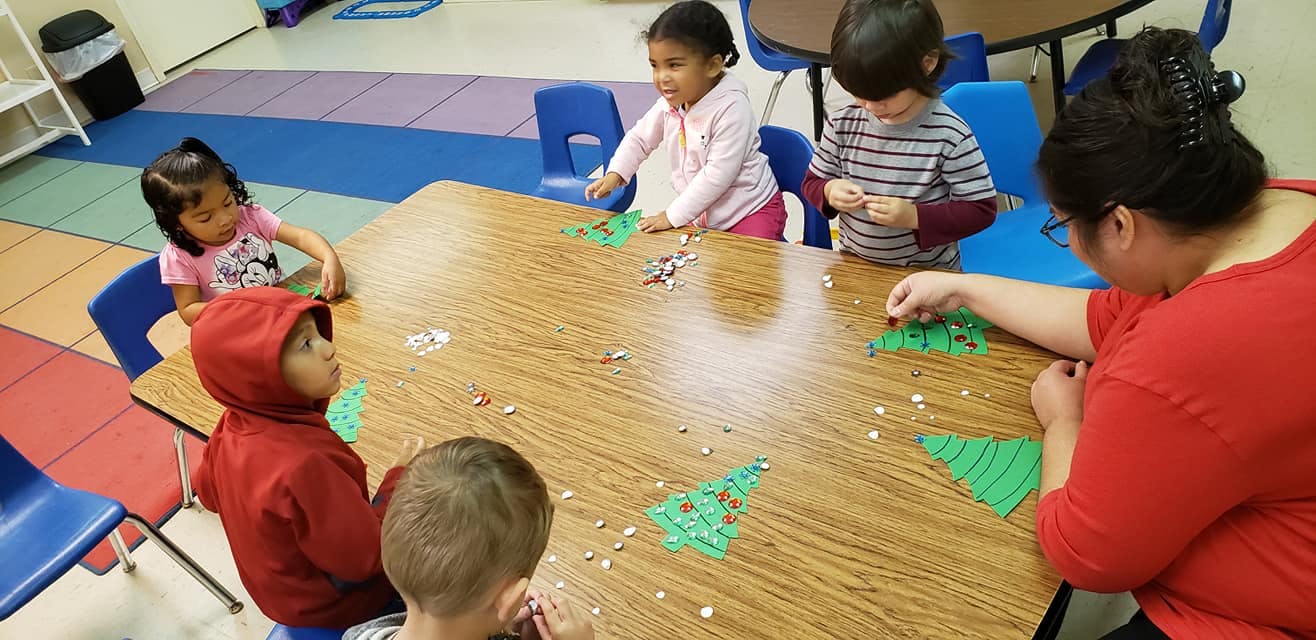 Adult and children doing crafts at a table