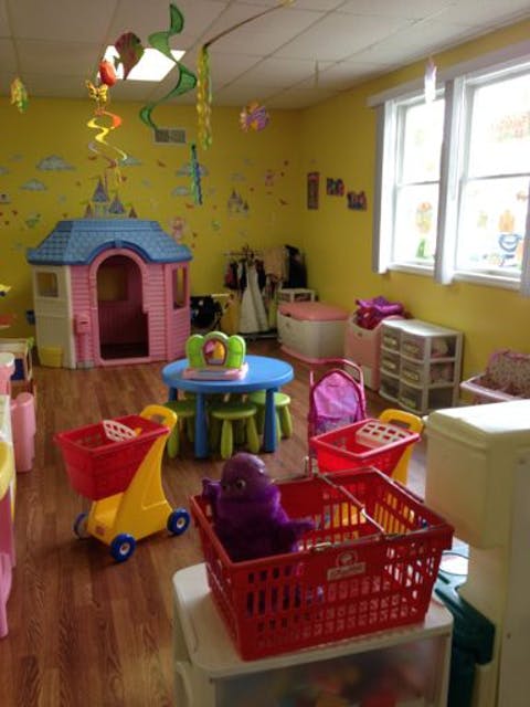 Playroom with a toy house, small table and chairs, and toy shopping carts