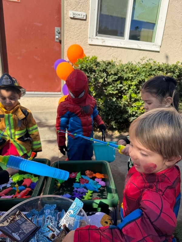 Children in costumes playing a game with fishing rods and toys