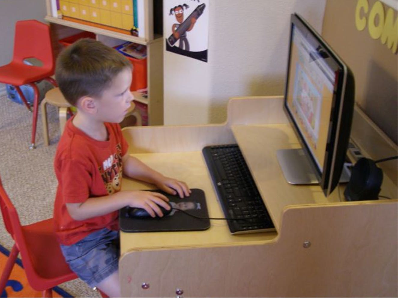 Child using a computer mouse at a desk