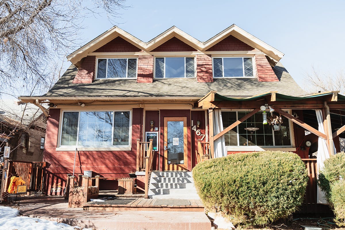 Red house with multiple dormer windows and a front porch