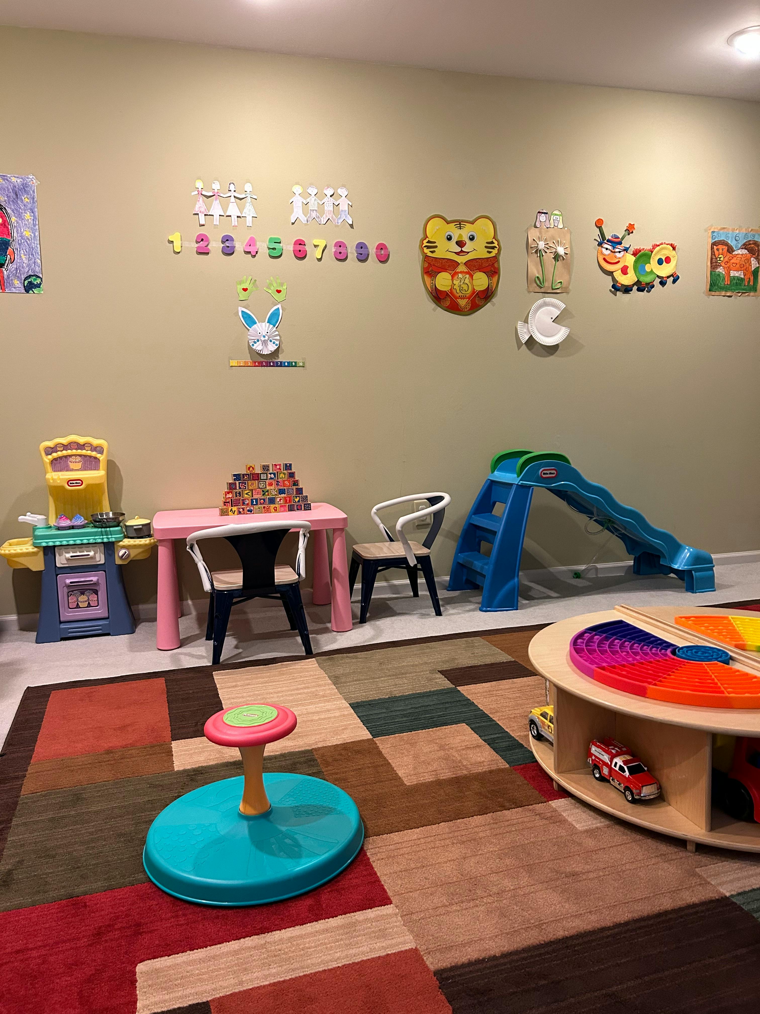 Children's play area with a table, chairs, slide, and toys