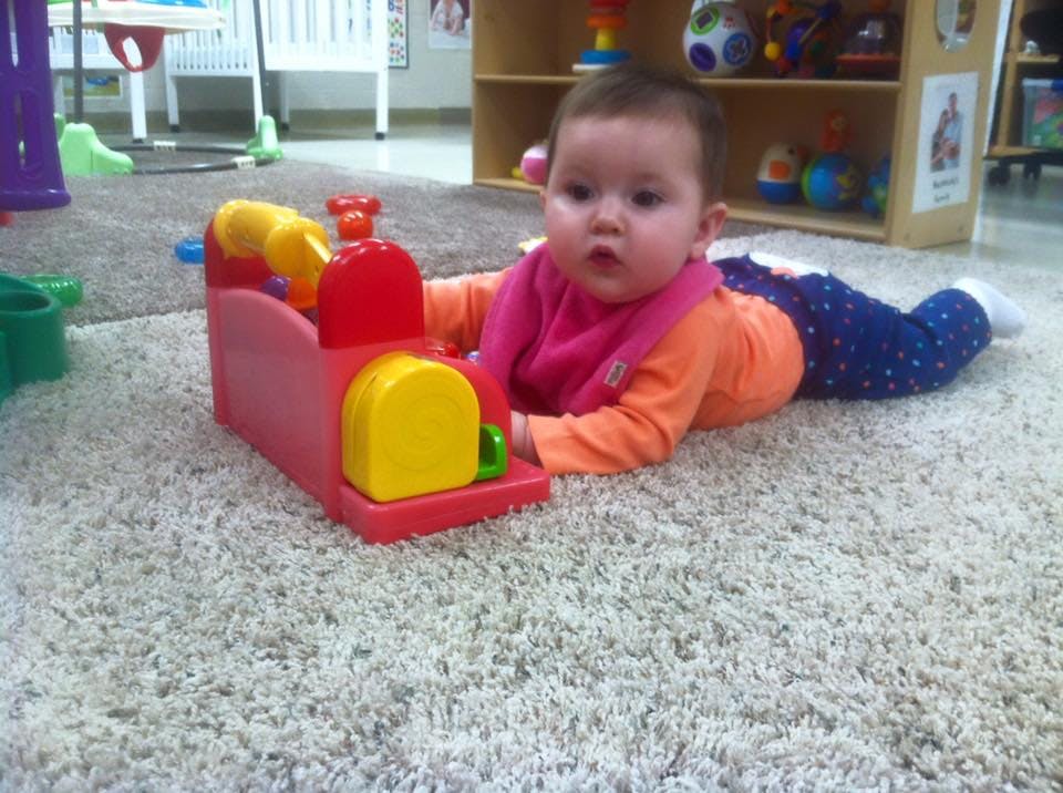 Child on carpet playing with a toy