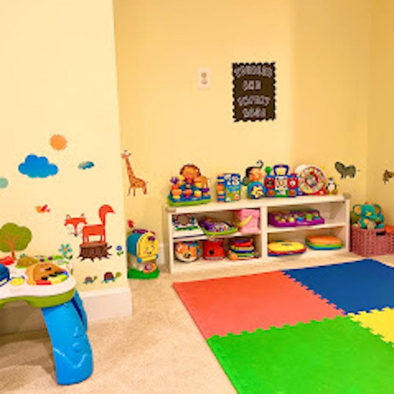 Playroom with wall decals, toy shelf, and colorful floor mats