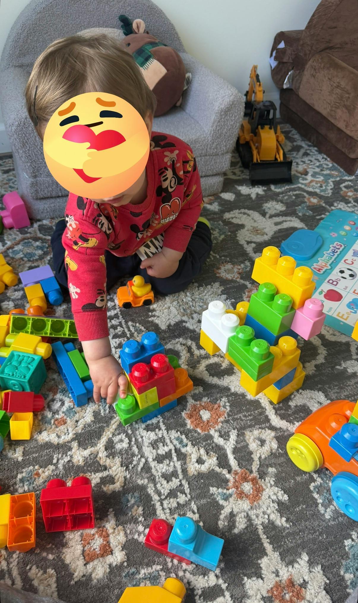 Child playing on floor with colorful building blocks