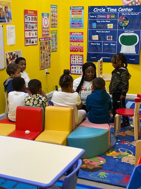 Adult and children sitting on floor in classroom