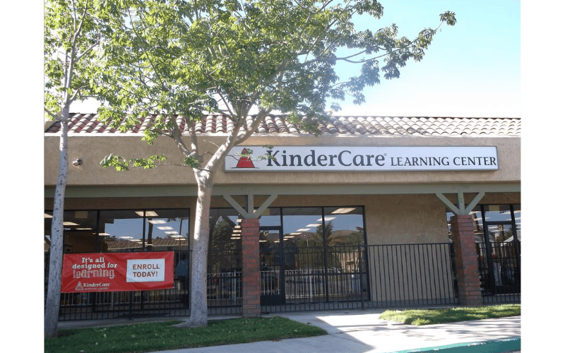 KinderCare Learning Center building exterior with a red "Enroll Today" banner