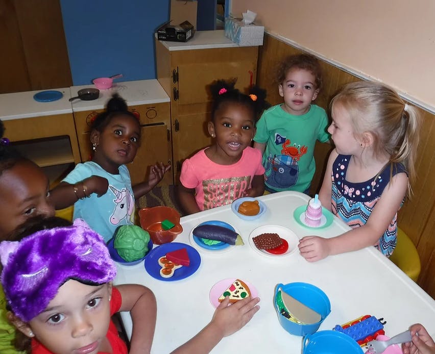 Children playing with toy food at a table
