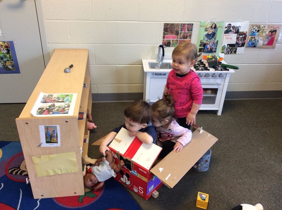 Three children playing with cardboard boxes