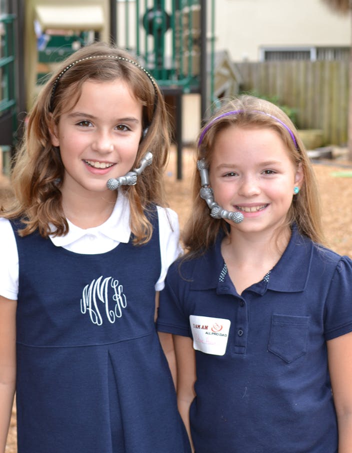 Two children wearing headsets and smiling