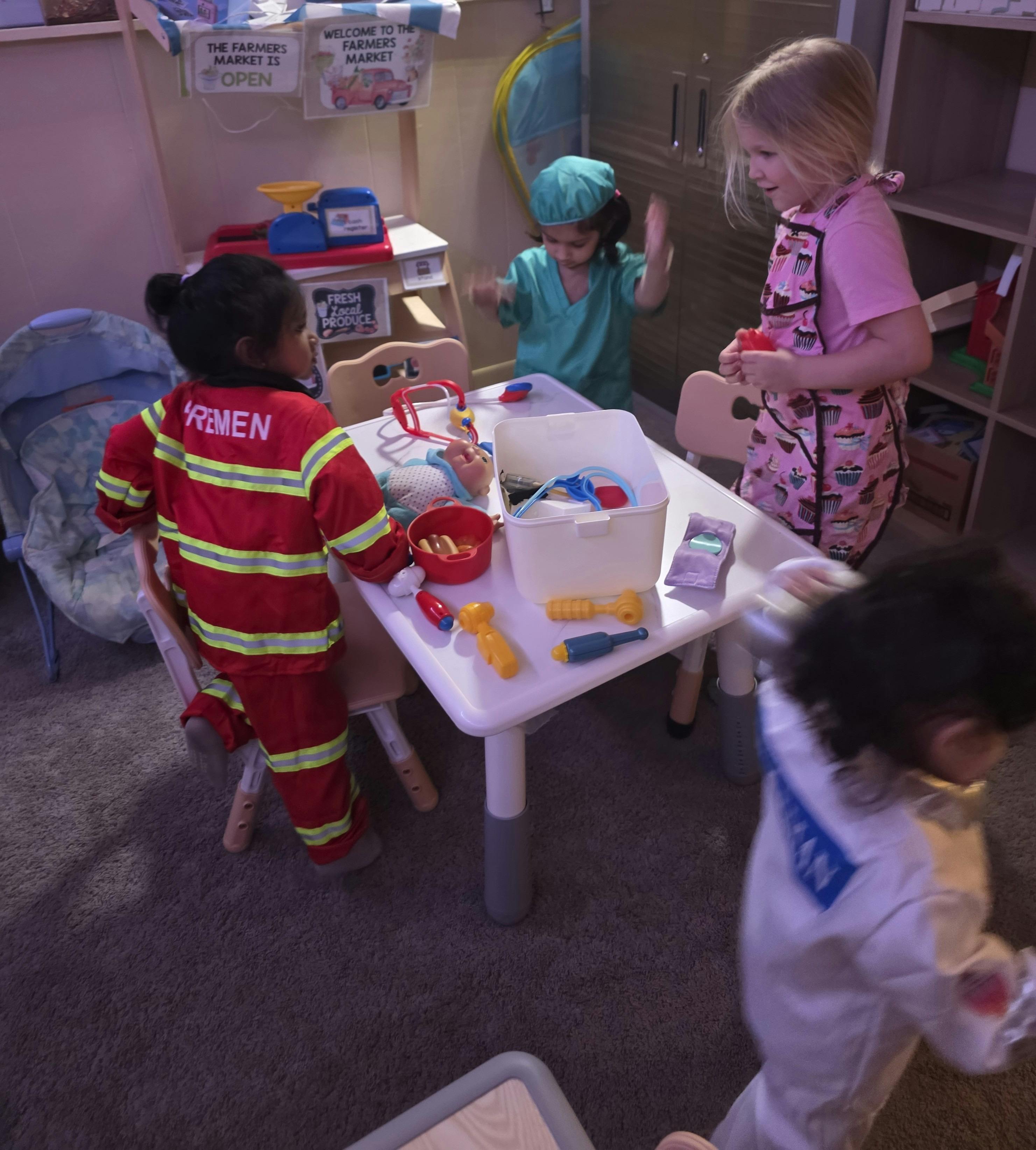 Children playing with toy medical equipment at a table