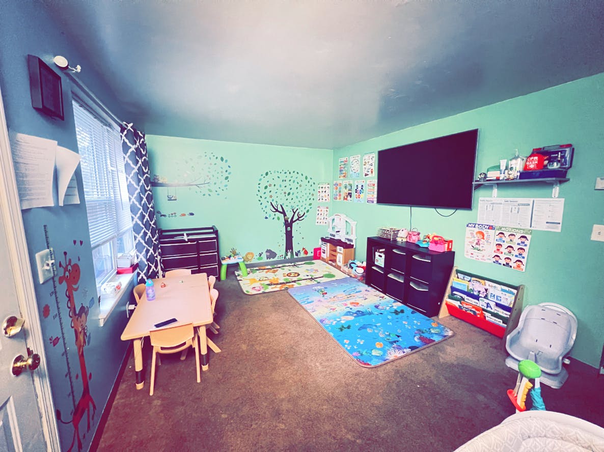 Playroom with small table and chairs, rugs, and wall decorations