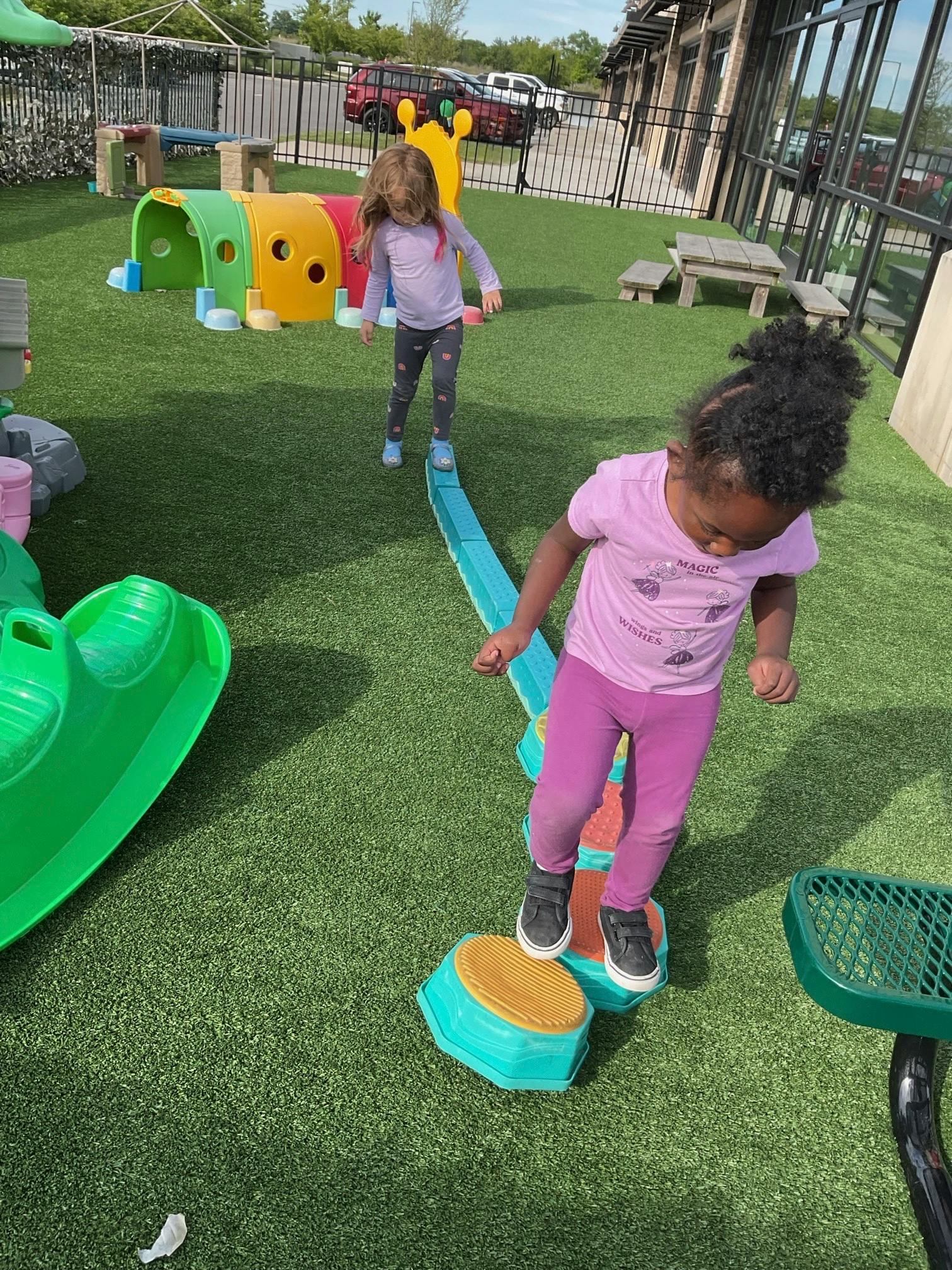 Children balancing on plastic equipment at a playground