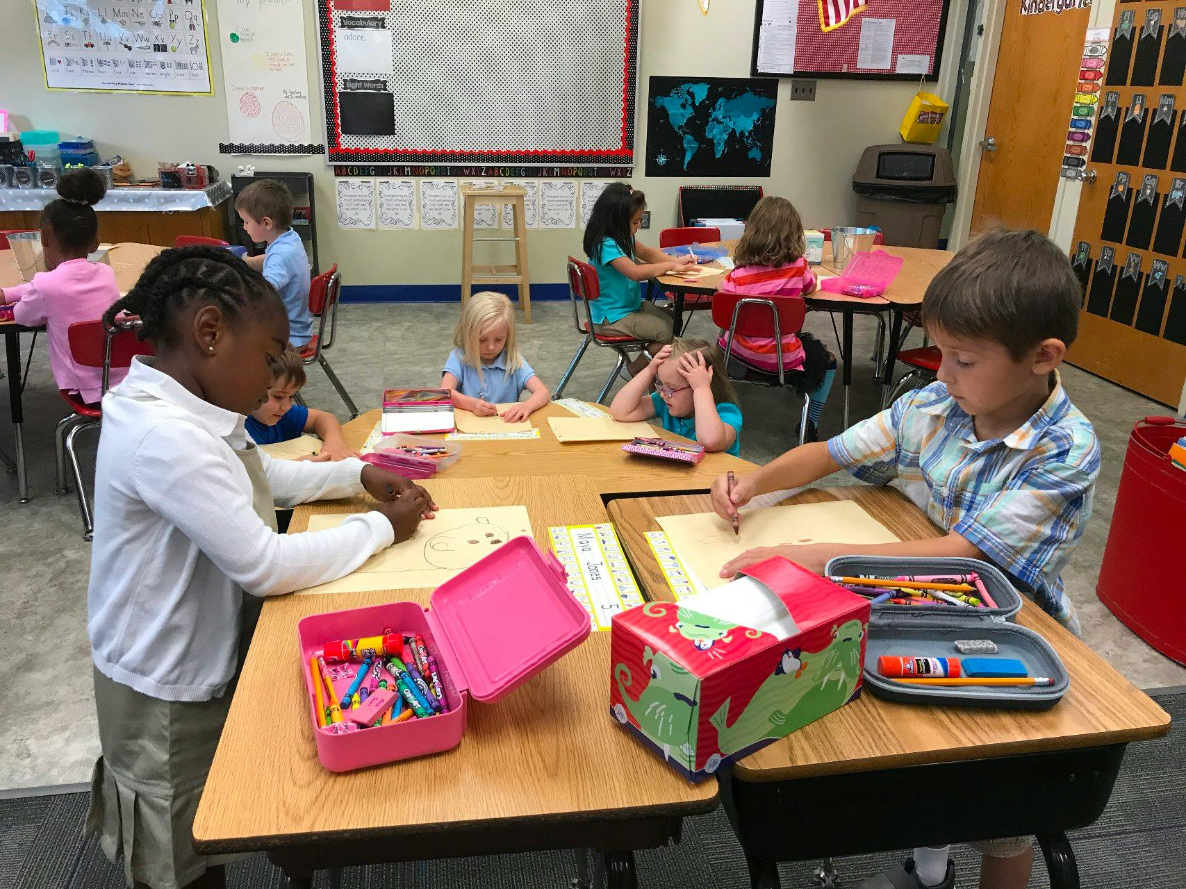 Children drawing at desks in a classroom
