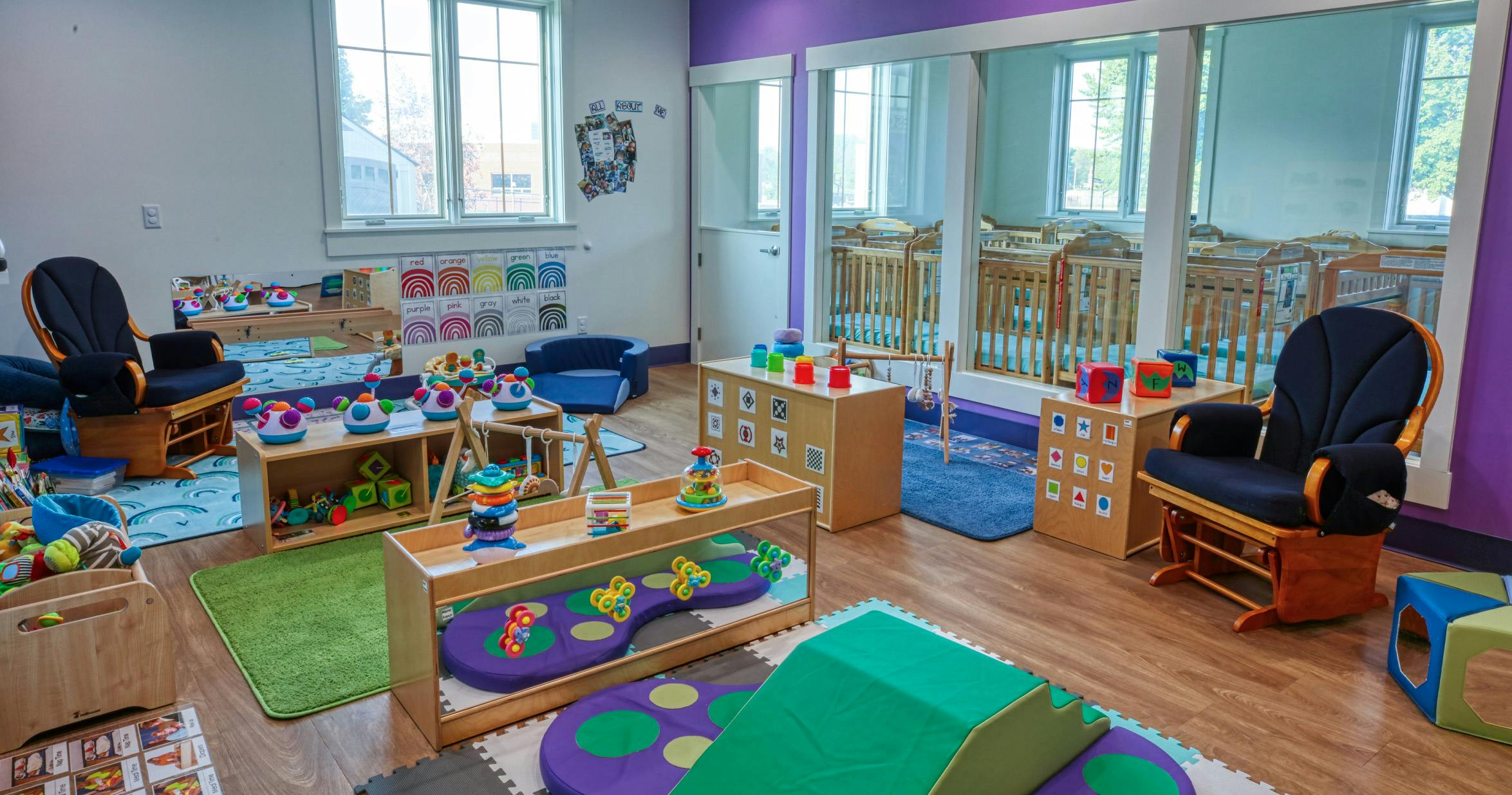 Classroom with cribs, play mats, and learning toys