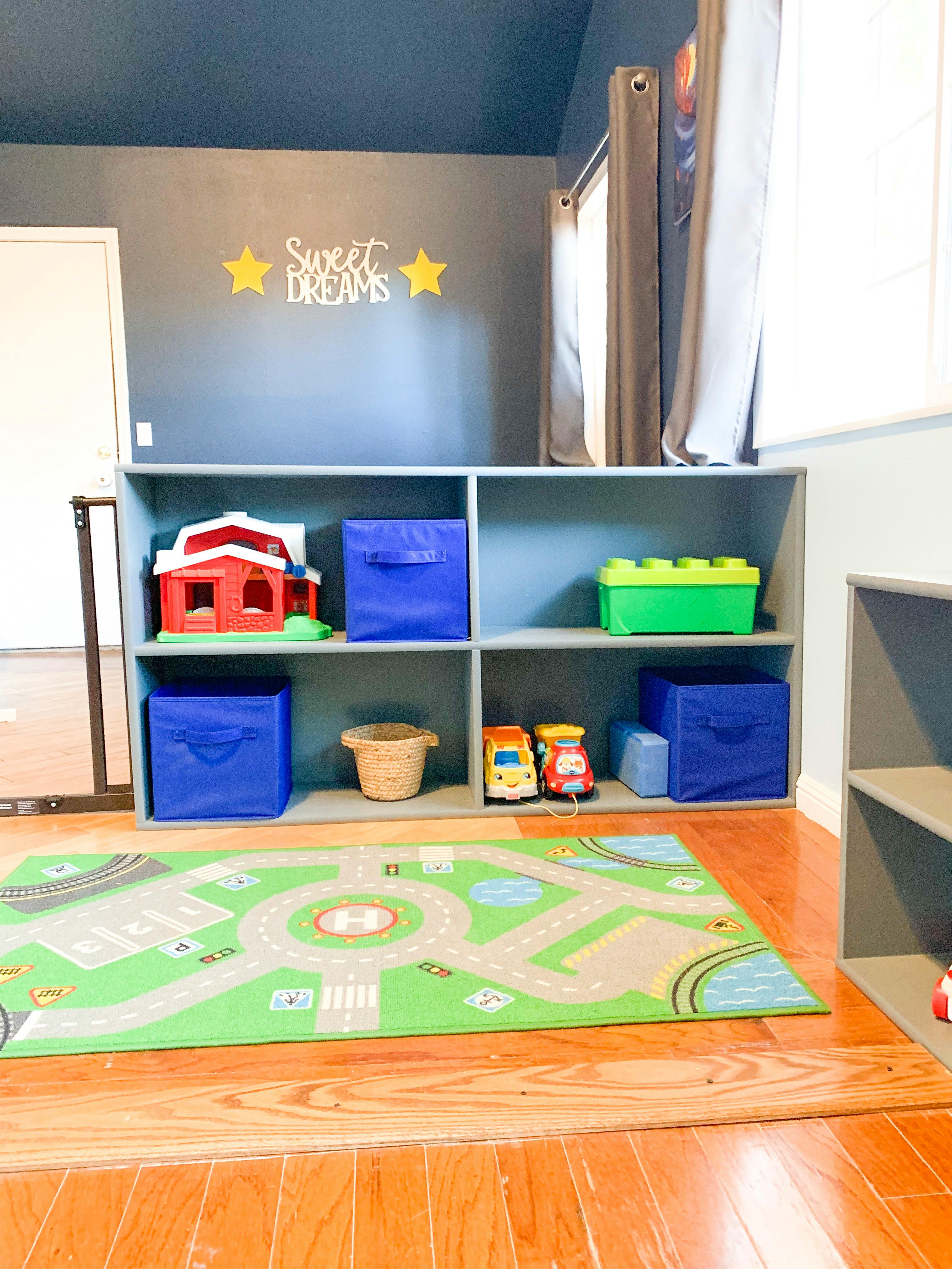 Playroom with toy shelf, play mat, and wall decor that says "Sweet Dreams"