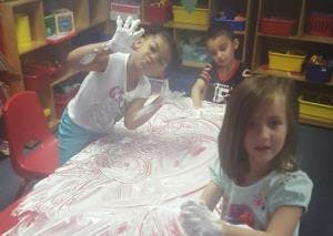 Children playing with shaving cream on a table