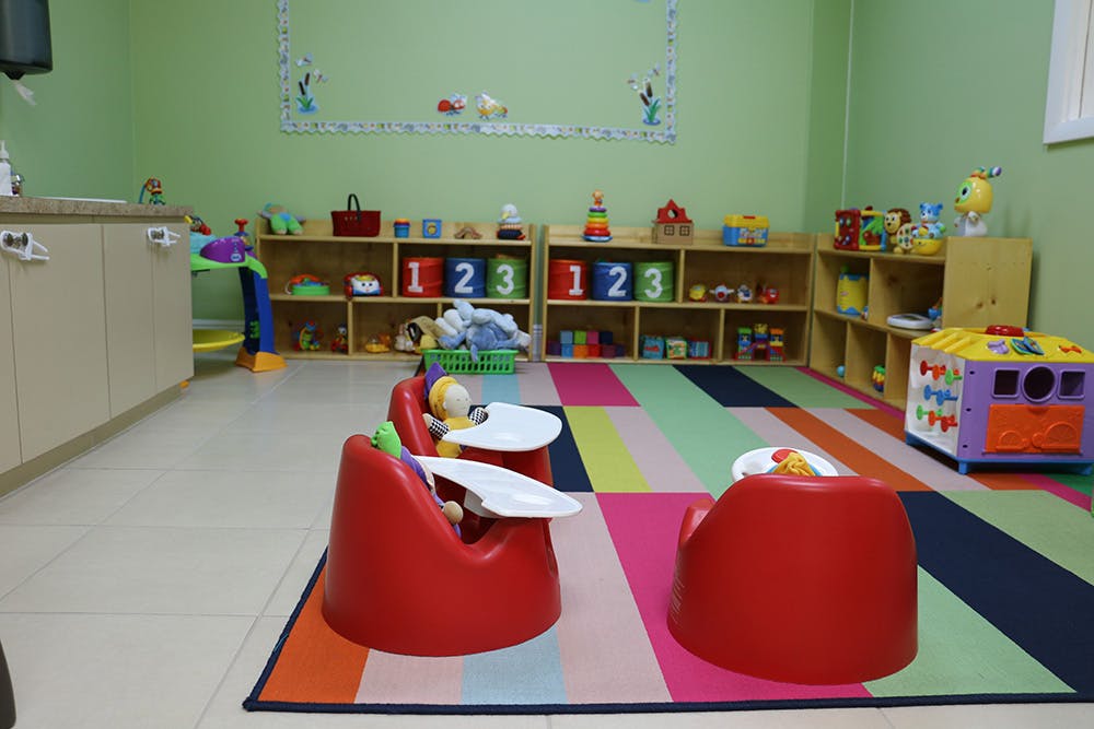 Playroom with red infant seats on a colorful striped rug