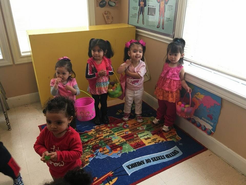 Four children holding baskets in a room