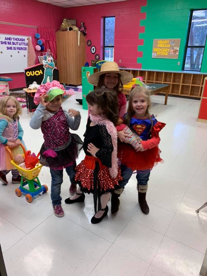 Five children in costumes standing together in a room