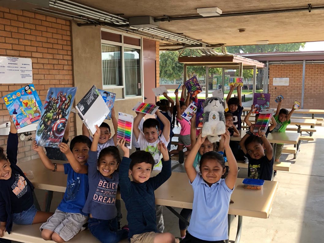 Children holding up school supplies