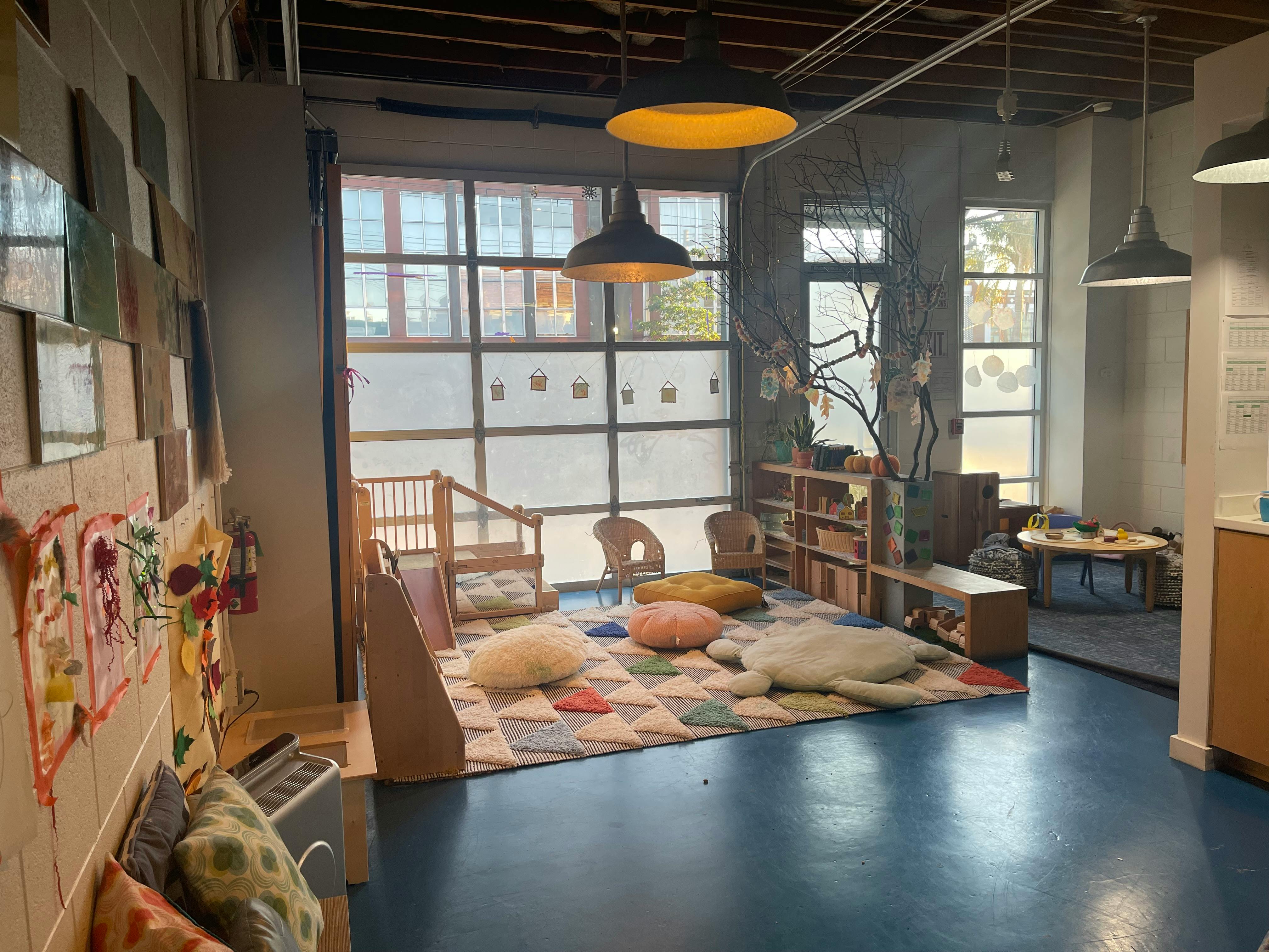 Playroom with floor cushions, low tables, and large windows