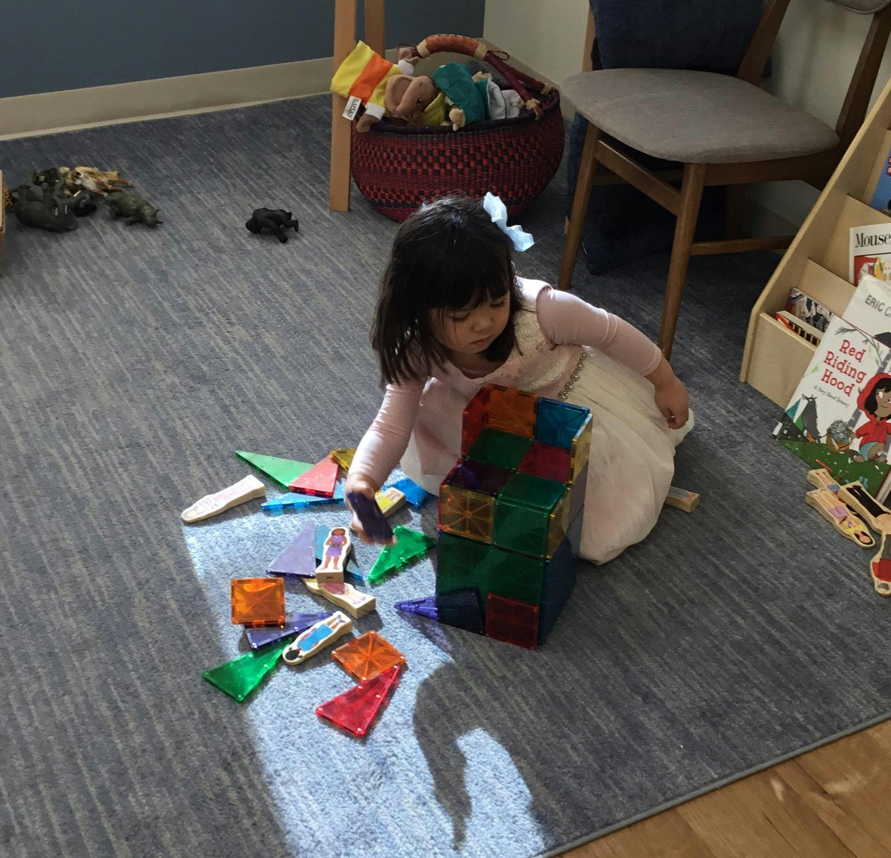 Child playing with colorful magnetic blocks on the floor