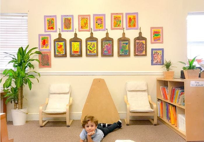 Child lying on the floor in a room with artwork on the wall
