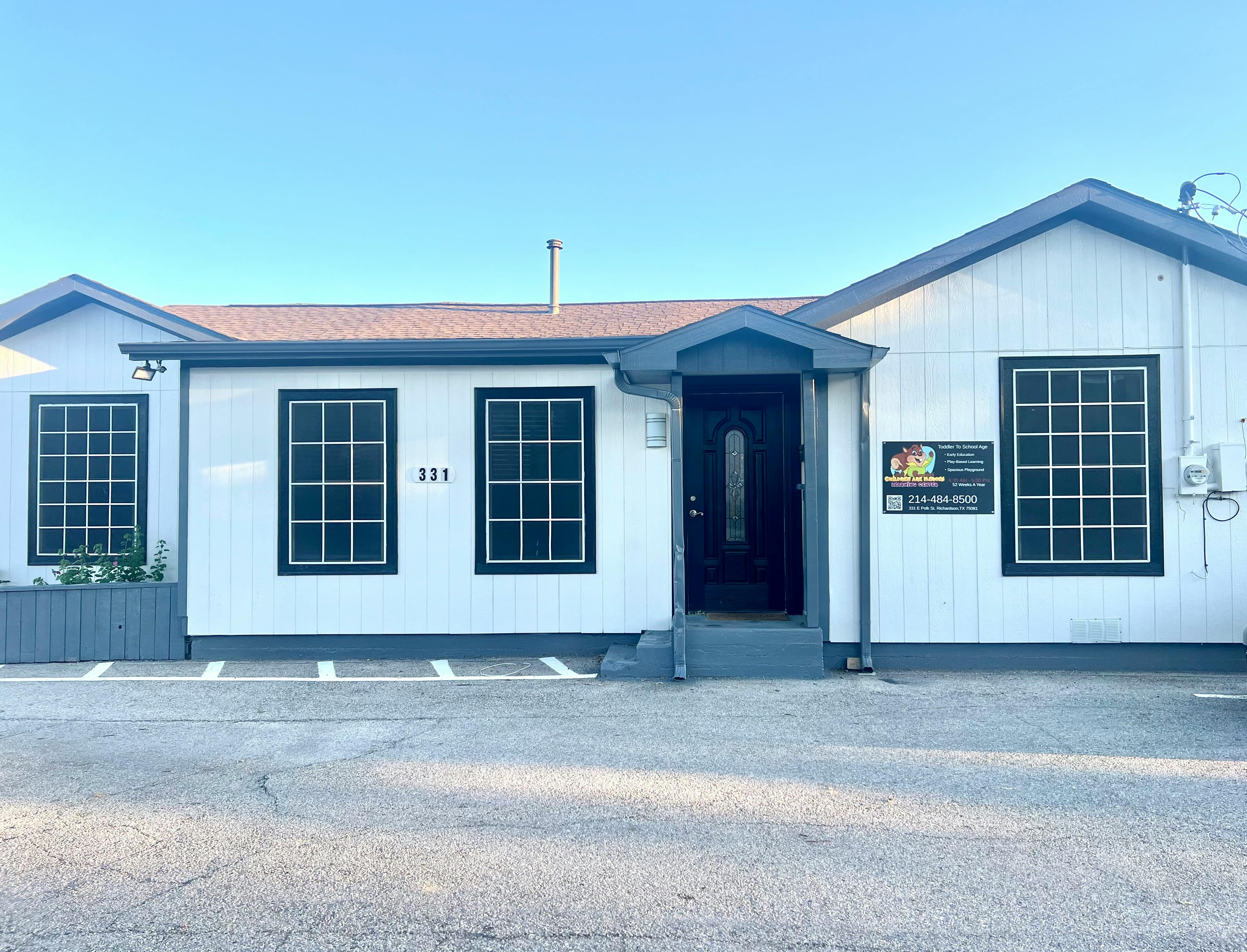 White building with dark windows and a dark front door