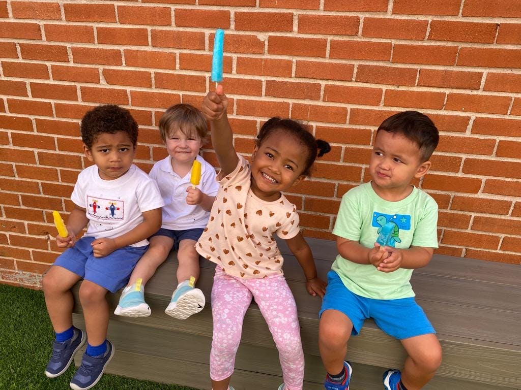 Four children sitting with popsicles