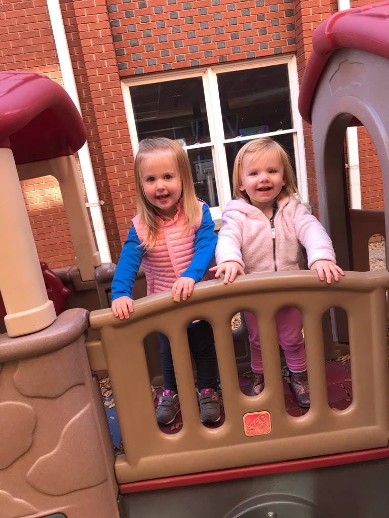 Two children standing on a playground structure