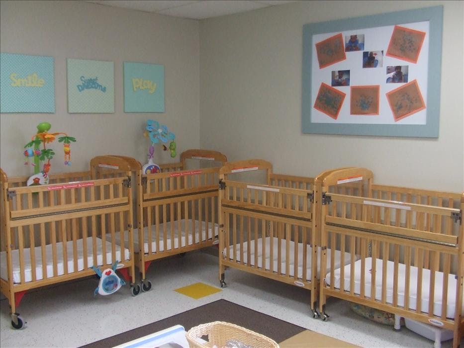 multiple wooden cribs with mattresses in a nursery room