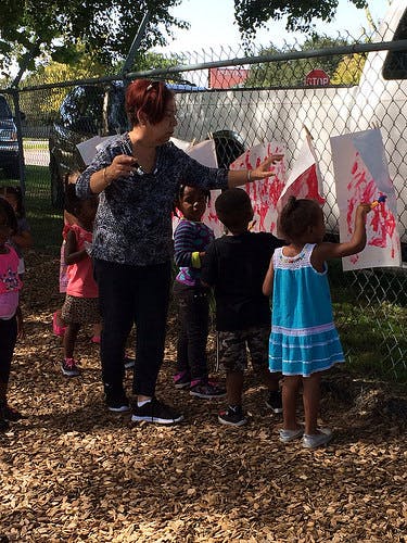 Adult and children painting outdoors