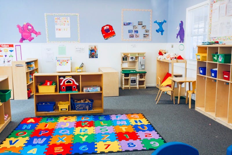 Playroom with colorful alphabet mat and wooden shelves