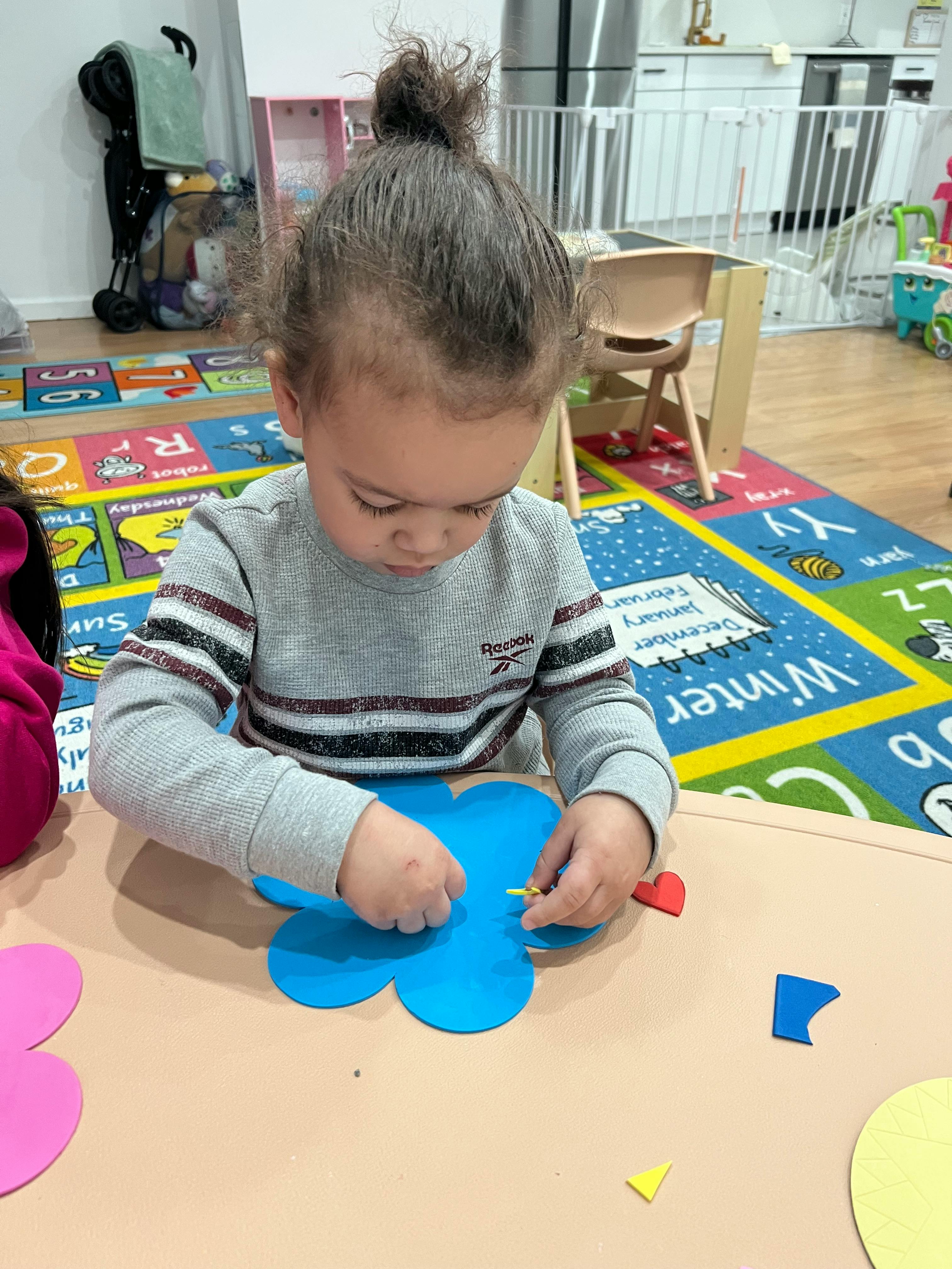 Child working on a craft project at a table