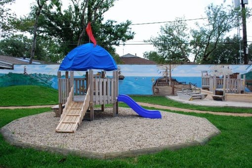 Playground with a wooden structure, blue slide, and blue canopy