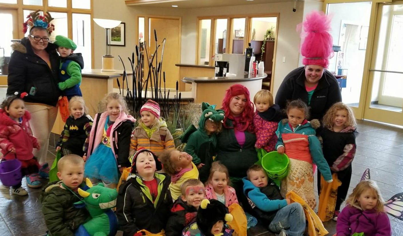 Two adults and multiple children in costumes