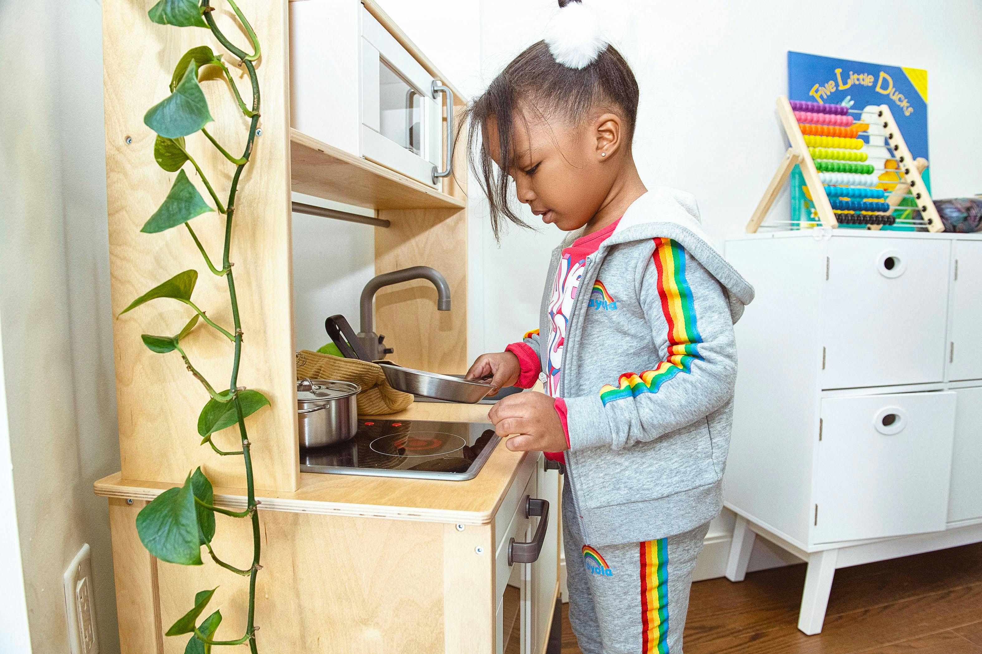 Child playing with a toy kitchen set