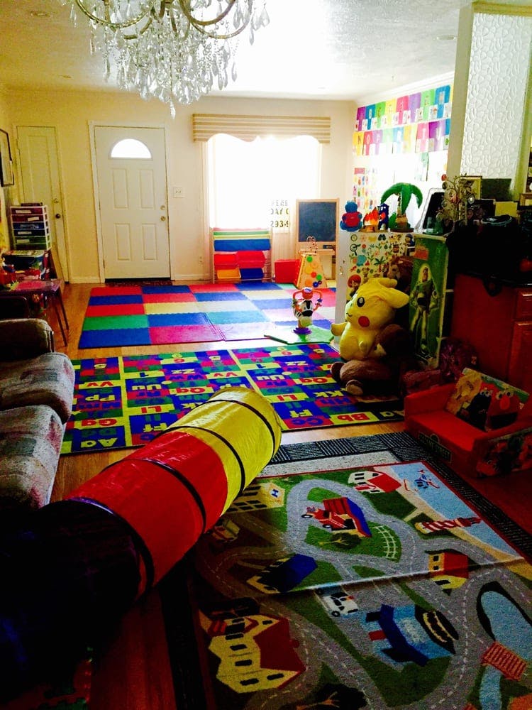 Playroom with colorful floor mats, toys, and a play tunnel