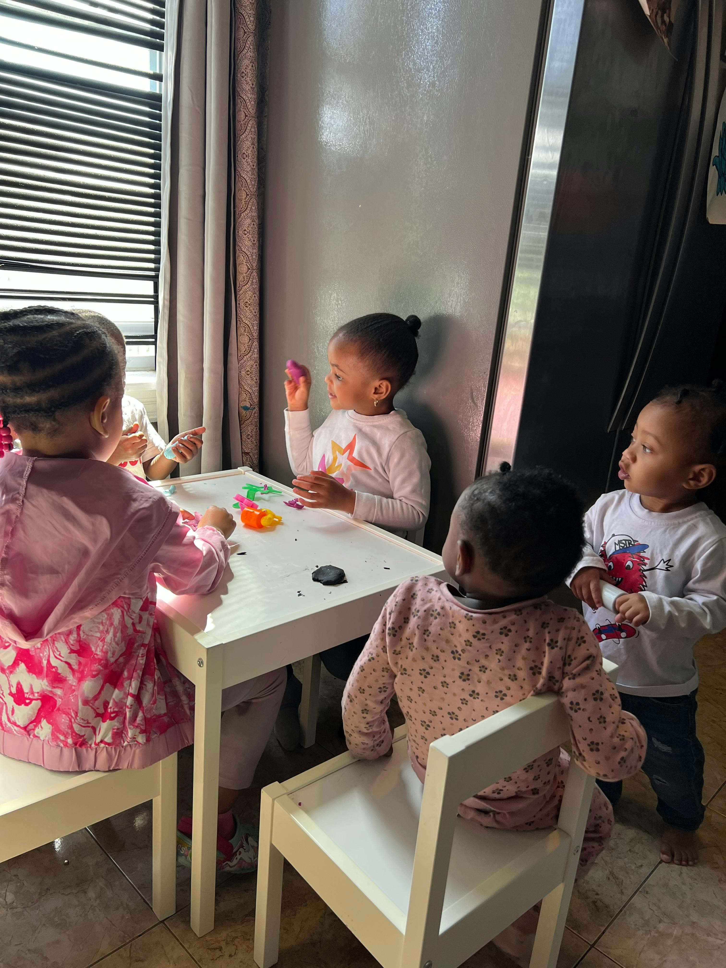 Children playing with toys at a small table