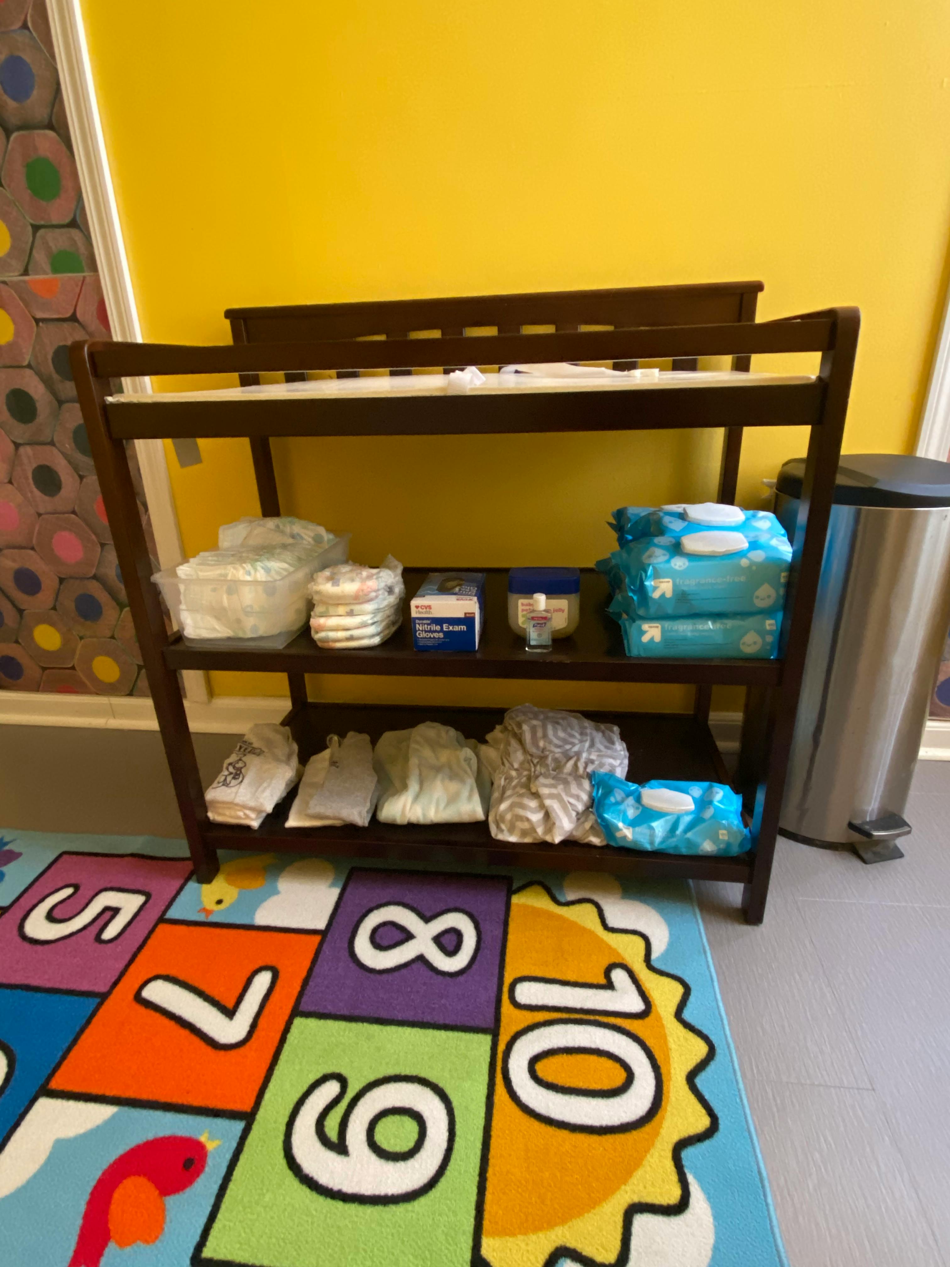Changing table with diapers and wipes on shelves