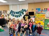 Adult and children posing in a classroom
