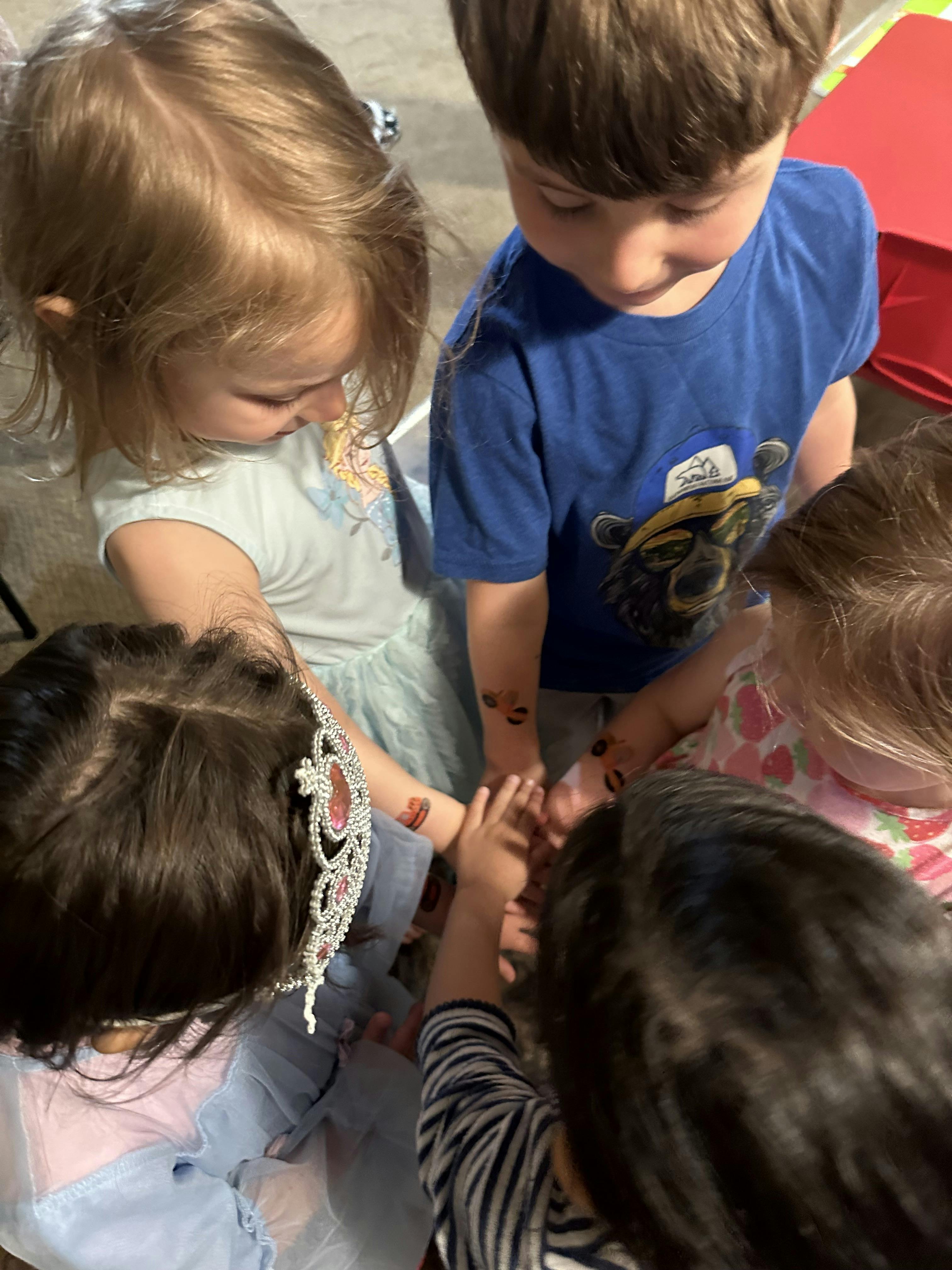 Group of children gathered in a circle, hands together