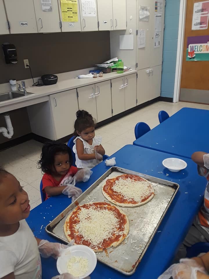 Children making pizzas in a classroom