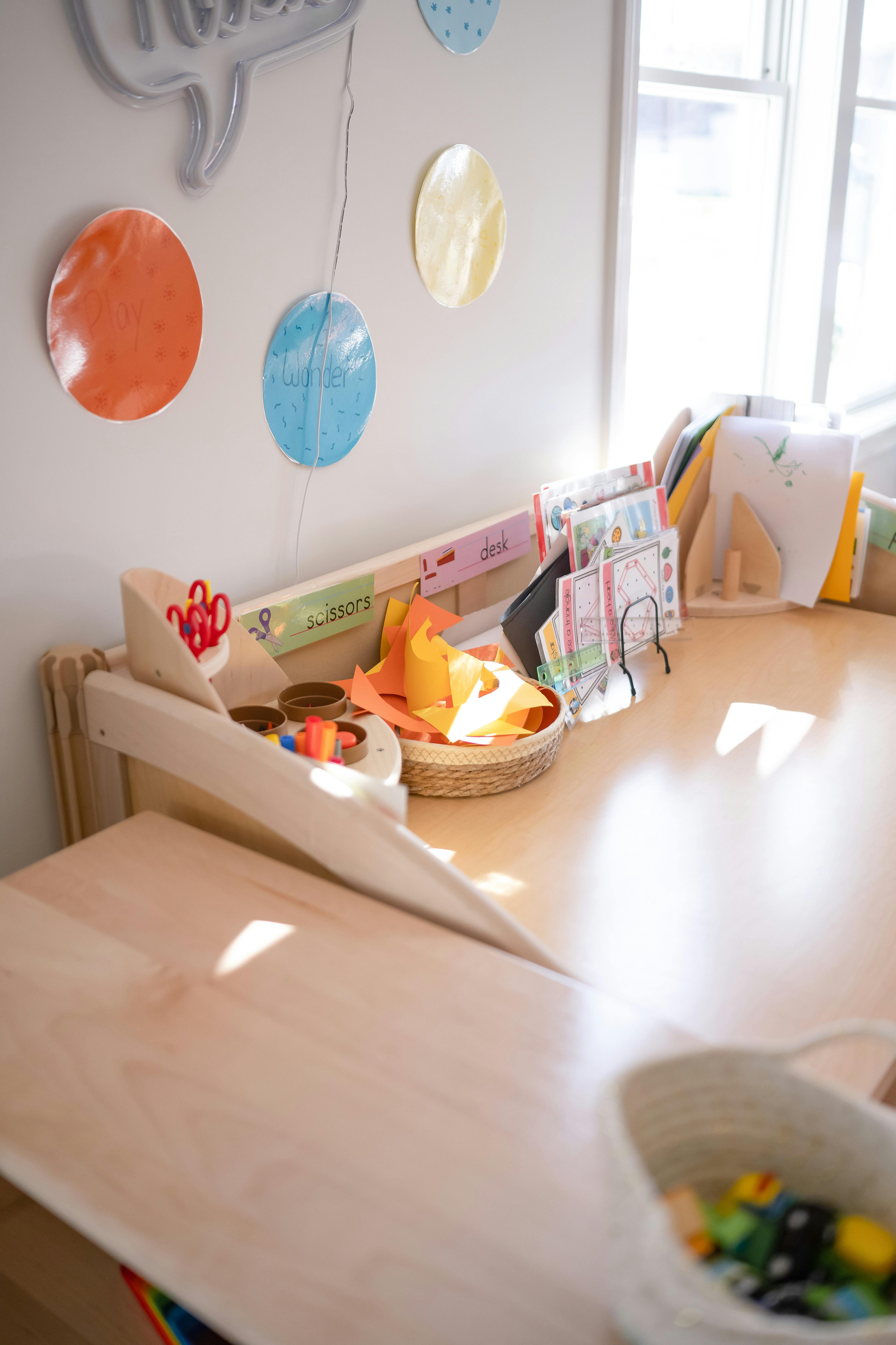 Classroom desk with art supplies and papers