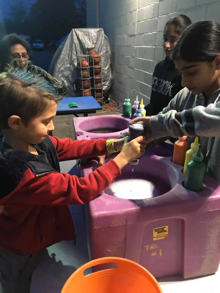 Two children using a purple wash station with soap and water