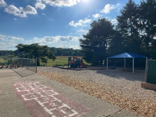 A hopscotch court and playground with a blue canopy
